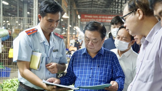 Bộ trưởng Bộ NN-PTNT Lê Minh Hoan (đứng giữa, mặc áo xanh) khảo sát tại khu rau quả chợ Bình Điền. Ảnh: HOÀNG HÙNG