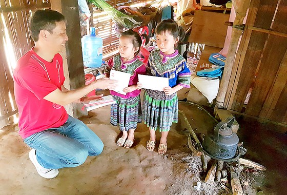 Ông Hiroshi Yokota ,Tổng giám đốc Công ty Canon Việt Nam, tặng quà học sinh nghèo xã Nà Hầu