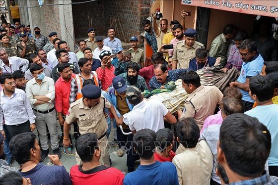 Lực lượng cứu hộ chuyển những nạn nhân trong vụ sập mái giếng bậc thang ở đền thờ tại bang Madhya Pradesh. Ảnh: AFP/TTXVN