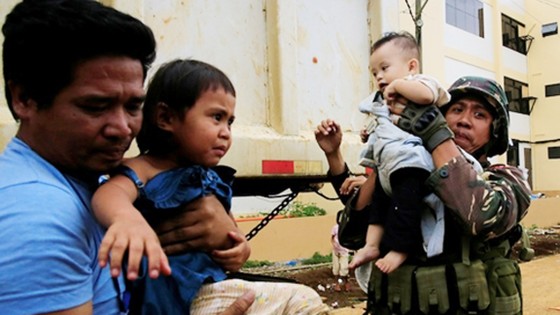 Bùng phát giao tranh giữa quân chính phủ và lực lượng phiến quân là một trong những nguyên nhân khiến Tổng thống Philippines Rodrigo Duterte đuối sức. Hình ảnh binh sĩ Philippines và nhân viên cứu hộ giải cứu hai trẻ em ở Marawi. Ảnh: REUTERS