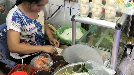 Người bán hàng dùng tay trần chế biến thức ăn cho khách Ảnh: HOÀNG HÙNG