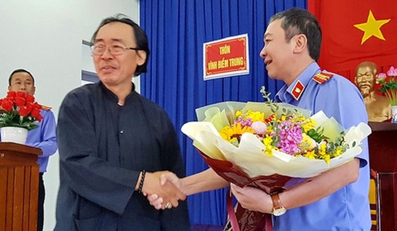 Viện trưởng Viện KSND TP Nha Trang trao hoa và bắt tay ông Thái Xuân Đàn tại buổi xin lỗi công khai. Nguồn: cand.com.vn