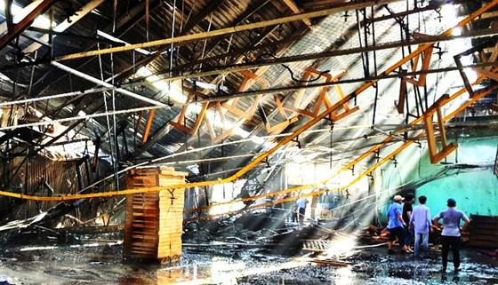 Lực lượng chức năng, công nhân nỗ lực dập tắt đám cháy  kho nhà xưởng TP Quy Nhơn, Bình Định trong ngày 30-7. Ảnh: XUÂN HUYÊN