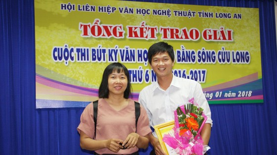 Tác giả trẻ Trương Chí Hùng nhận giải nhất cuộc thi Bút ký ĐBSCL năm 2018, bên cạnh là nhà văn Nguyễn Ngọc Tư. Ảnh: QUỐC TUẤN
