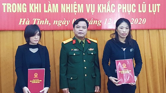 Đại tá Lê Hồng Nhân - Chỉ huy trưởng Bộ CHQS tỉnh trao các quyết định tuyển dụng cho vợ của 2 liệt sĩ