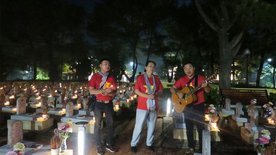  Các nghệ sĩ thắp nến và hát tri ân tại Nghĩa trang Liệt sĩ quốc gia Trường Sơn, Quảng Trị. Ảnh: MINH HIỆP