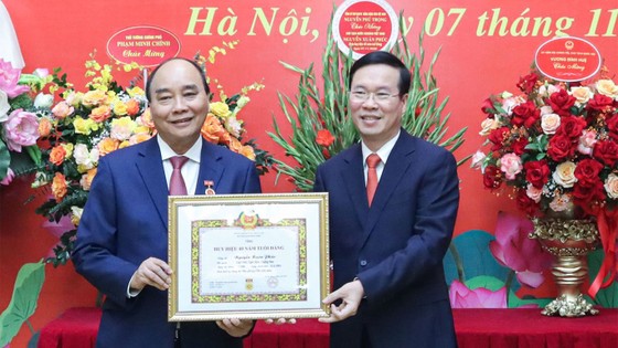 Thường trực Ban Bí thư Võ Văn Thưởng trao Huy hiệu 40 năm tuổi Đảng tặng Chủ tịch nước Nguyễn Xuân Phúc. Ảnh: QUỐC HÙNG