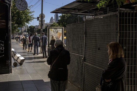 People line up a block away from Banco de la Nacion in Buenos Aires, Argentina, on April 3.  Photographer: Sarah Pabst/Bloomberg