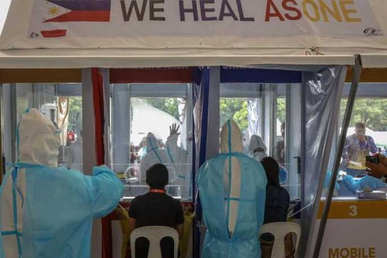 Nhân viên y tế xét nghiệm cho nhân viên chính phủ ở TP Quezon, Đông Bắc Manila hôm 30-7. Ảnh: EPA
