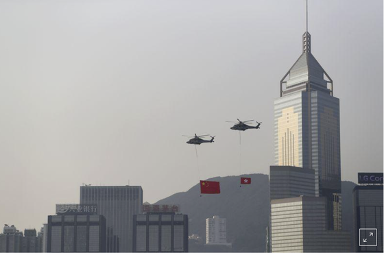 Máy bay trực thăng mang cờ Trung Quốc và cờ Hồng Kông bay ngang qua đường chân trời của Cảng Victoria vào Ngày Quốc khánh của Trung Quốc ở Hồng Kông, ngày 1 tháng 10 năm 2019. REUTERS / Athit Perawongmetha / File Photo