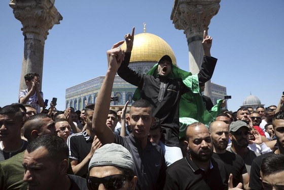 Tín đồ Hồi giáo đội cờ Hamas trong cuộc biểu tình phản đối các cuộc không kích của Israel ở Dải Gaza trước nhà thờ Al-Aqsa, tại Thành Cổ Jerusalem, ngày 14/5/2021. Ảnh: AP ảnh 5 Chú thích ảnh
