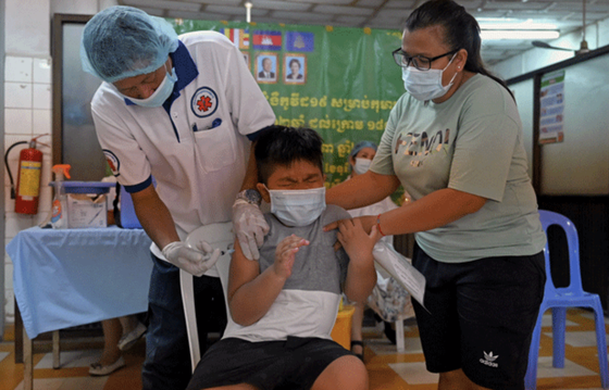 Một bé trai Campuchia tiêm vaccine. @AFP