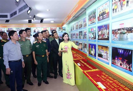 Visitors take a look at photos displayed at the exhibition on cooperation milestones among public security forces of Vietnam, Cambodia and Laos. (Photo: VNA)