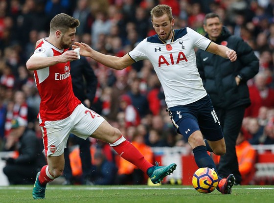 Shkodran Mustafi (trái, Arsenal) ngăn chặn pha tấn công của Harry Kane (Tottenham)
