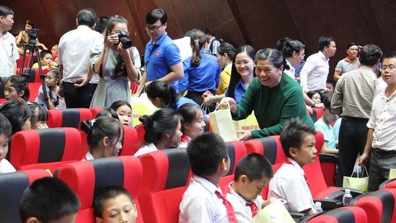 Phó Chủ tịch Quốc hội Tòng Thị Phóng xuống từng hàng ghế để tặng quà cho các em thiếu nhi. Ảnh: congthuong.vn