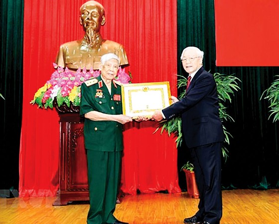 Tổng Bí thư, Chủ tịch nước Nguyễn Phú Trọng, Bí thư Quân ủy Trung ương, trao Huy hiệu 70 năm tuổi Đảng tặng đồng chí Lê Khả Phiêu ngày 25-8-2019. Ảnh: TTXVN