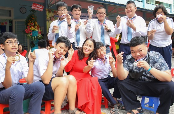 Cô Lê Thị Kim Chi, Giám đốc Trung tâm Hỗ trợ phát triển giáo dục hòa nhập Tân Bình (quận Tân Bình) cùng các học trò của mình. Ảnh: HOÀNG HÙNG