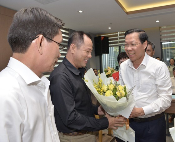 Chủ tịch UBND TPHCM Phan Văn Mãi tặng hoa chúc mừng các Chủ tịch hội đồng hiệu trưởng khối ngành. Ảnh: CAO THĂNG