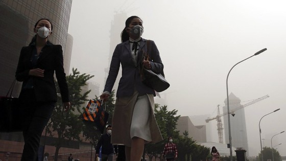 Nhân viên văn phòng ở thủ đô Bắc Kinh phải mang mặt nạ bảo vệ đi làm (tháng 5-2017). Ảnh: AP
