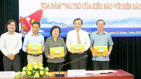Ông Hoàng Chí Hùng (bìa trái), Chủ nhiệm CLB Ảnh báo chí  Hội Nhà báo TPHCM, tặng các đại biểu sách ảnh về biển đảo