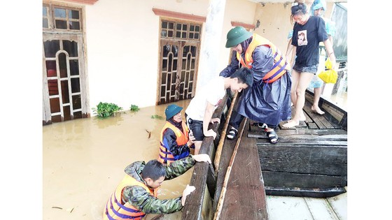Cán bộ xã Tân Ninh giúp dân lên thuyền chạy lũ