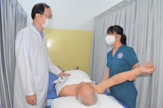 ThS-BS Trịnh Quang Anh (trái), Trưởng Đơn vị Hiệu chỉnh cơ xương khớp và y học thể thao, Bệnh viện 1A, thăm khám cho bệnh nhân