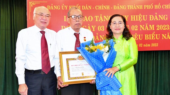 Chủ tịch HĐND TPHCM Nguyễn Thị Lệ và Trưởng Ban Tuyên Giáo Thành ủy TPHCM trao Huy hiệu 60 năm tuổi Đảng cho đồng chí Võ Văn Cương. Ảnh: VIỆT DŨNG