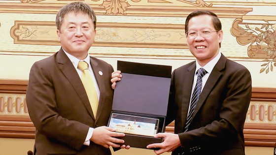 Chủ tịch UBND TPHCM Phan Văn Mãi tặng quà lưu niệm ông Shimizu Akira, Trưởng Đại diện Văn phòng JICA Việt Nam tại buổi tiếp. Ảnh: MINH HIỆP