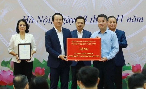 Ông Trần Long, Phó Tổng giám đốc BIDV (bên trái) đại diện ngân hàng trao tặng 12.000 thẻ BHYT trị giá 5 tỷ đồng