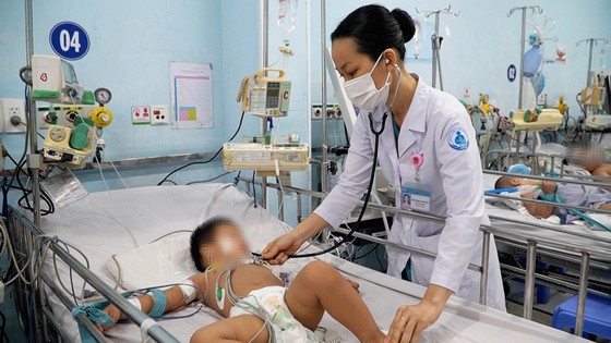 Bác sĩ Bệnh viện Nhi đồng 1 (TPHCM) thăm khám trẻ mắc tay chân miệng. Ảnh: THÀNH SƠN
