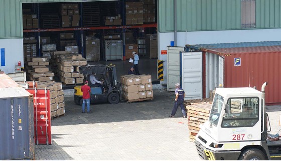 Hàng hóa tại kho vận Tân Cảng - Cát Lái đang được vận chuyển xuất nhập vào các container Ảnh: HOÀNG HÙNG