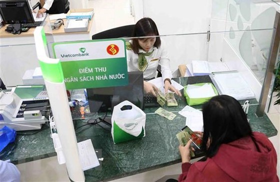 Người dân nộp thuế tại điểm thu Ngân hàng Vietcombank. (Ảnh: Vũ Sinh/TTXVN)