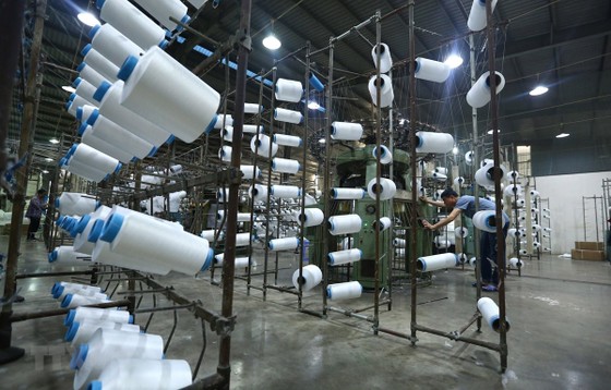 Công nhân làm việc tại nhà máy sợi Huế thuộc Công ty Cổ phần Dệt may Huế. (Nguồn: TTXVN)