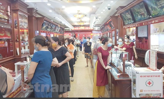Nhiều người dân xếp hàng mua bán vàng tại Bảo Tín Minh Châu trên phố Trần Nhân Tông, Hà Nội chiều ngày 6/8. (Ảnh: PV/Vietnam+)