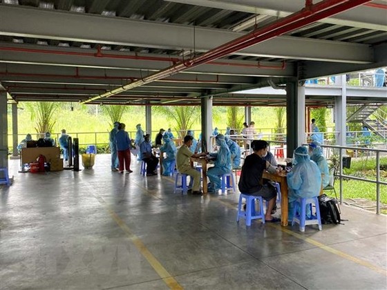 Tiêm vaccine phòng COVID-19 cho công nhân làm việc tại Khu chế xuất Tân Thuận. (Ảnh: Thanh Vũ/TTXVN)