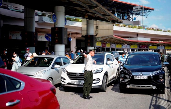Phía trước nhà ga, lực lượng An ninh kiểm soát sân đỗ ôtô tăng cường điều tiết dòng xe vào khu vực Cảng hàng không quốc tế Nội Bài. (Ảnh: CTV/Vietnam+)