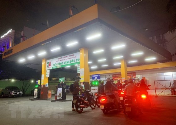 Người dân mua xăng tại Cửa hàng xăng dầu trên đường Hoàng Văn Thụ (quận Phú Nhuận, Thành phố Hồ Chí Minh), tối ngày 12/10. (Ảnh: Hồng Đạt/TTXVN)