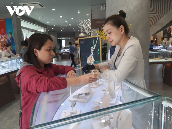 Nhân viên bán hàng đang tư vấn cho khách hàng mẫu nữ trang vàng cho ngày Vía Thần tài.