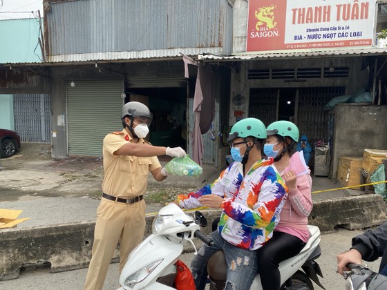 CSGT TPHCM hỗ trợ nước, sữa, khẩu trang... cho người dân trên đường về miền Tây ảnh 2