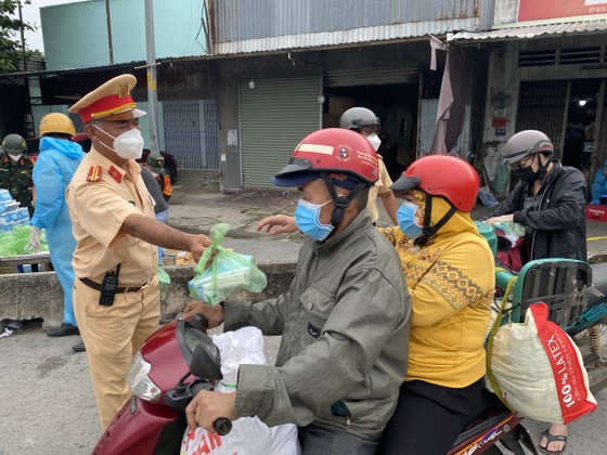 CSGT TPHCM hỗ trợ nước, sữa, khẩu trang... cho người dân trên đường về miền Tây ảnh 6