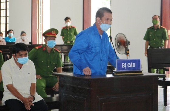 Bị cáo Phạm Văn Cung (áo xanh) và bị cáo Nguyễn Tuấn Sĩ tại phiên xét xử sơ thẩm. Ảnh: QUỐC AN