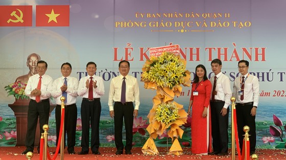 Bí thư Quận ủy quận 11 Trương Quốc Lâm; Quyền Chủ tịch UBND quận 11 Nguyễn Trần Bình tặng hoa chúc mừng nhà trường. Ảnh: CHÍ THẠCH