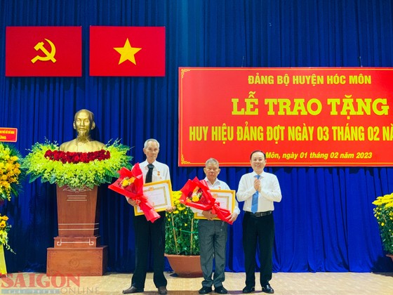 Phó Bí thư Thành ủy TPHCM Nguyễn Văn Hiếu trao Huy hiệu Đảng đợt 3-2 cho các đảng viên cao tuổi Đảng ở huyện Hóc Môn. Ảnh: CHÍ THẠCH