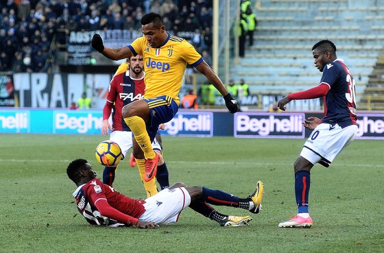 Hậu vệ Alex Sandro (Juventus) tránh cú tắc bóng gai góc của các hậu vệ Bologna. Ảnh: Getty Images. 