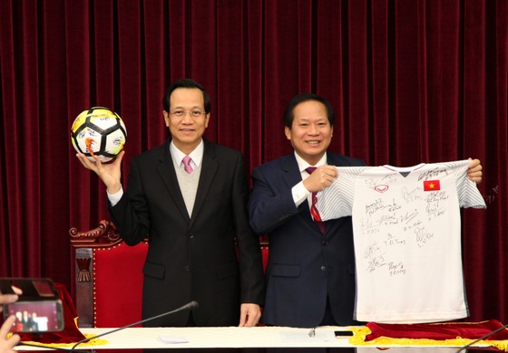 Bộ trưởng Bộ LĐ-TB&XH Đào Ngọc Dung (trái) và Bộ trưởng Bộ Thông tin và Truyền thông Trương Minh Tuấn nhận trái bóng, chiếc áo đấu của U23 Việt Nam tặng Thủ tướng Chính phủ để chuẩn bị đấu giá. Nguồn: VGP