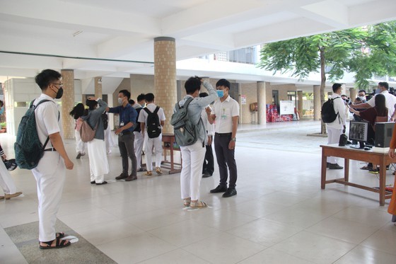Học sinh các trường đều mang khẩu trang và giữ khoảng cách khi bước vào trường học, địa điểm thi