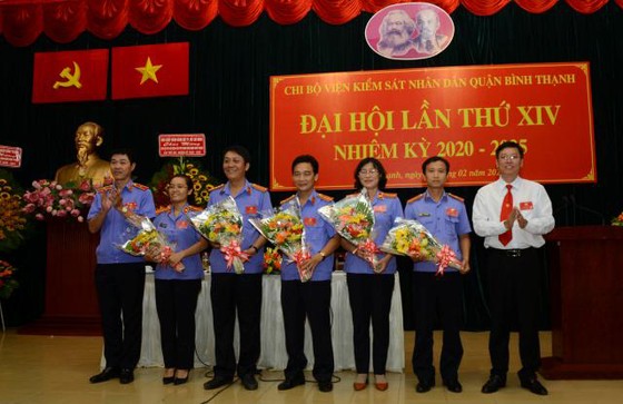 Đồng chí Mai Trung Thành (trái) và đồng chí Vũ Ngọc Tuất (phải) tặng hoa chúc mừng cấp ủy Chi bộ Viện Kiểm sát nhân dân quận nhiệm kỳ 2020 - 2025. Ảnh: VM