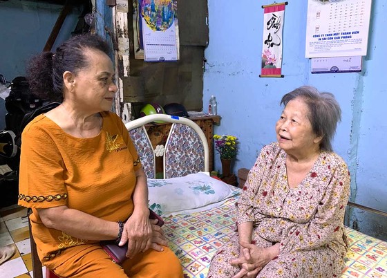 Bà Nguyễn Thị Hường, Phó Chủ nhiệm CLB Hội mẹ truyền thống quận 1 (trái), thăm hỏi sức khỏe một hộ nghèo tại phường Đa Kao. Ảnh: THÁI PHƯƠNG