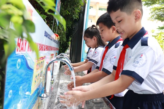 Niềm vui của các em học sinh khi được sử dụng nước sạch. Ảnh: ĐINH BÍCH