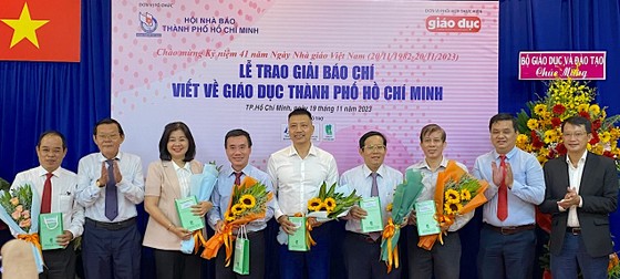 Đại diện Bộ GD-ĐT, Bộ LĐTB-XH và Hội Nhà báo TP tặng hoa cám ơn các đồng chí là tổng biên tập, phó tổng biên tập - thành viên Ban giám khảo chấm giải thưởng. Ảnh: AN KHÁNH